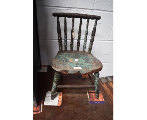 An antique apprentice style miniature chair with bobbin back and shaped seat.
