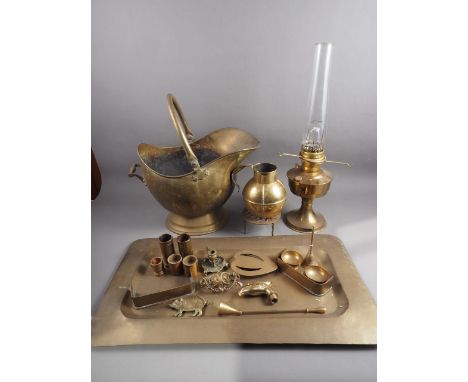 An assortment of brassware including a tray, 24 1/4" wide, a coal helmet, an oil lamp, a Jersey jug, trivets and other items 