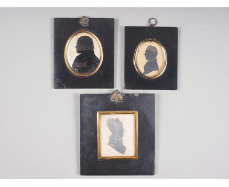 A 19th century portrait miniature silhouette of a man and two similar portraits, in ebonised frames 