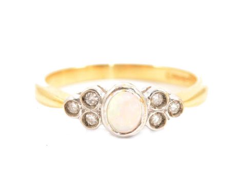 An opal and diamond ring, the oval cabochon cut opal with three brilliant cut diamonds collet set to each side, in an 18 cara