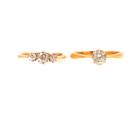 A diamond three stone ring, the old brilliant cut stones claw set in a yellow and white metal mount ring size M, shank marked