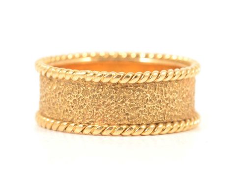 P Pike &amp; Partners - an 18 carat yellow gold band, molten finish texture to centre with a raised rope edge border, 8mm wid