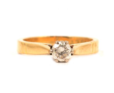 A diamond solitaire ring, the brilliant cut stone claw set in a yellow and white metal mount ring size Q, shank marked 18ct, 