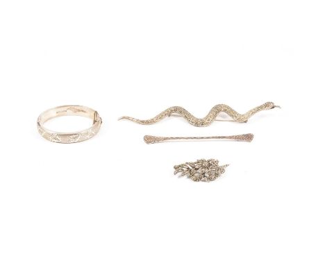 A silver 12mm wide hollow half hinged bangle with ivy leaf engraving to front, Birmingham 1967; a white metal 18cm snake desi
