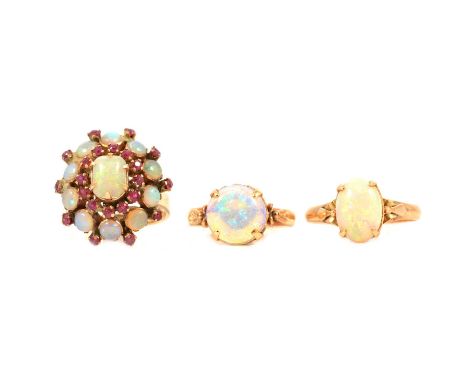 Three opal rings, an oval cabochon cut solitaire 11.4 x 8mm, four claw set in an all yellow metal mount ring size S, scroll d