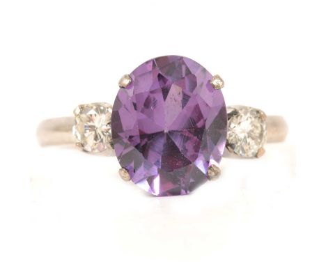 A purple synthetic corundum made to simulate alexandrite and diamond three stone ring, the oval mixed cut synthetic corundum 