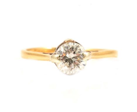 A diamond solitaire ring, the brilliant cut stone claw set in an 18 carat yellow and white gold mount ring size M, London imp