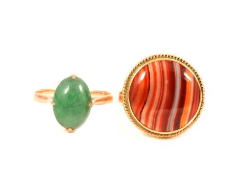 A banded agate ring and jade coloured ring, an orange circular cabochon cut banded agate, 17mm diameter collet set in a yello