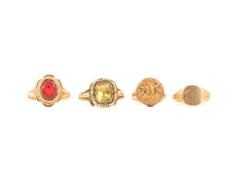 Four dress rings, a yellow metal ring set with a golden stone in closed back setting, ring size P, finely chased surround and