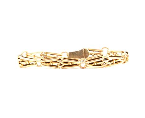 A yellow metal gate link bracelet, 8mm wide tapered bow shaped links with tongue snap fastener marked 15ct, 18cm long, 11.5g.