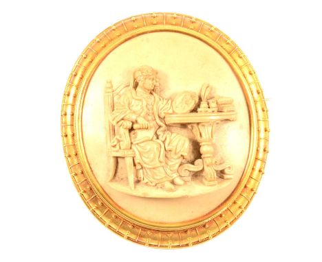 A large lava cameo brooch in gold coloured mount, the 50 x 40mm cameo having raised detail of a period gentleman seated at a 