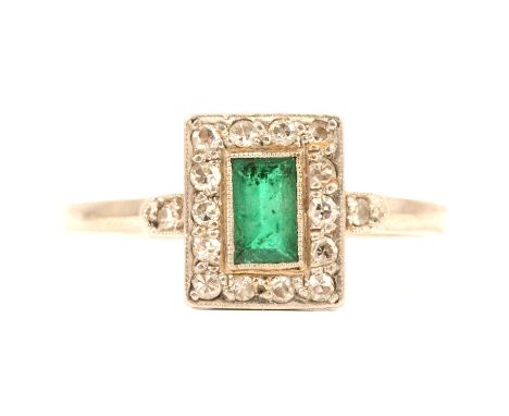 A rectangular emerald and diamond cluster ring, the step cut emerald 5.2 x 3mm, milgrain set and surrounded by fourteen dimon