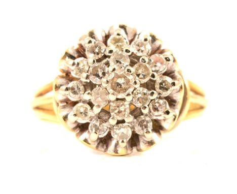 A circular diamond cluster ring, eighteen 8 cut diamonds surrounding a central brilliant cut diamond all claw set in a yellow