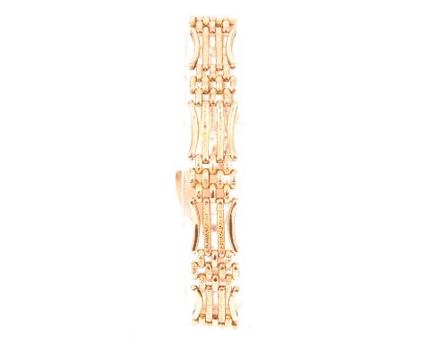 A yellow metal 12mm wide four bar gate link bracelet, the centre bars and smaller connecting links chased, fitted with a padl