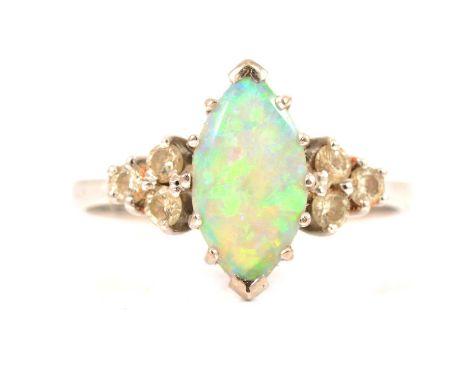 A marquise opal and diamond ring, the marquise cabochon cut 10.5x6mm opal with three small round brilliant diamonds claw set 