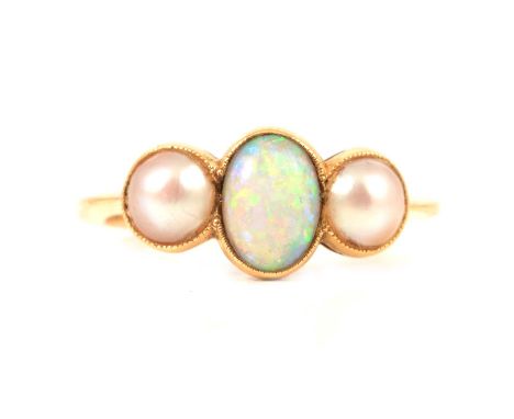 An oval cabochon cut opal and pearl three stone ring, the oval cabochon cut opal and pearls milgrain set in an all yellow met