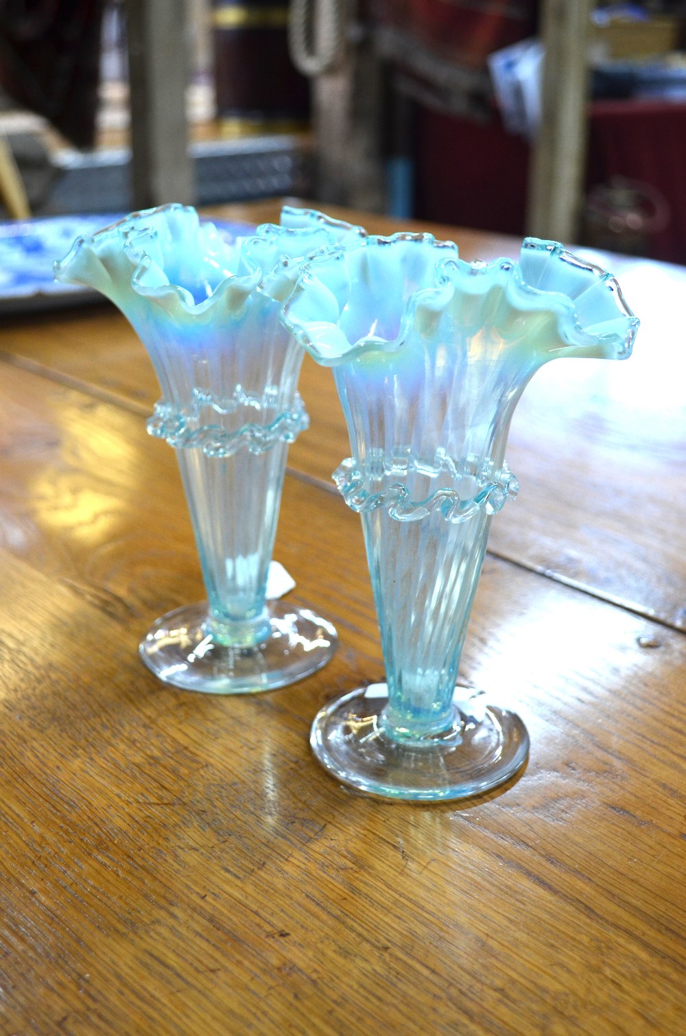 A pair of Victorian blue vaseline glass vases of conical form with ...