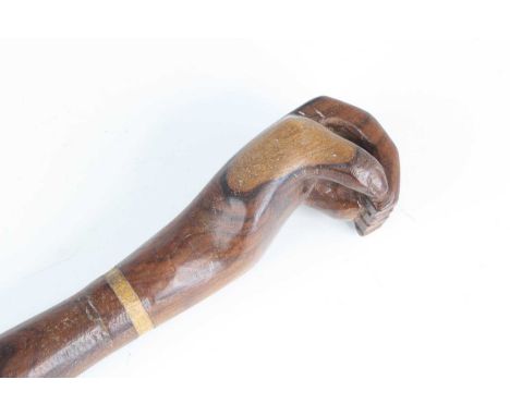 A 20th century Pitcairn Islands miro wood? walking stick, the terminal carved as a clenched fist, 92cm.
