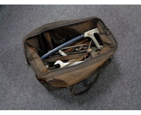 A vintage holdall of hand tools, folding wooden rule, ring spanners, hammers etc 