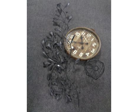 A circular contemporary metal cased wall clock together with two metal wall mounted wine racks and a wire metal shade. 