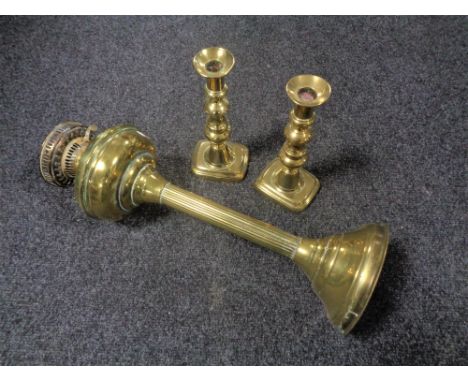 A Victorian brass oil lamp base, height 49 cm, together with a pair of candlesticks.