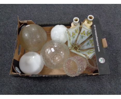 A box containing assorted glass light shades together with a pair of marble table lamps. 