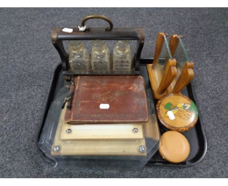 A tray containing Edwardian photograph frames, Treen pot, an album of cigarette cards, a miniature three bottle Tantalus. 