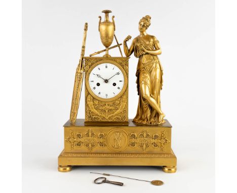 A mantle clock with elegant figurine, ormolu gilt bronze, Empire.Silk rope suspension and half-hour strike.&nbsp;19th century