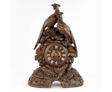 An antique 'Black Forest' mantle clock, decorated with sculptured wood pheasants. Circa 1900.&nbsp;Dimensions:(D:17 x W:44 x 