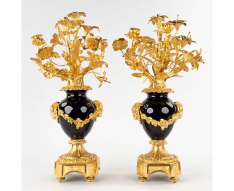 A pair of candelabra, gilt bronze on porcelain and decorated with flower decor.&nbsp;19th century.&nbsp;Dimensions:(D:30 x W: