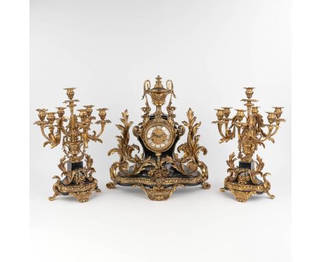 A three-piece mantle&nbsp;garniture clock and candelabra.Wood mounted with bronze in Louis XV style. Circa 1970.Height candel