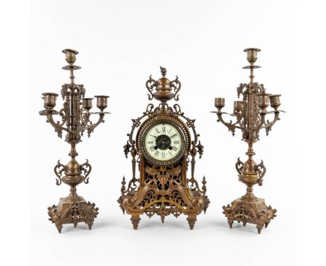 A three-piece mantle garniture clock and candelabra, patinated bronze. Circa 1900.&nbsp;Height of the candelabra: 47 cm.&nbsp