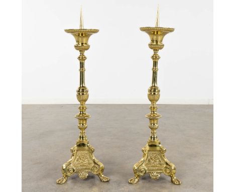 A pair of church candlesticks or candle holders&nbsp;polished bronze.Images of angles and standing on lion's feet.&nbsp;19th 