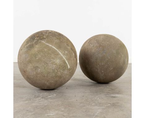 A pair of garden ornaments in the shape of a balls, sculptured Belgian bluestone.&nbsp;The first half of the 20th century.Dim
