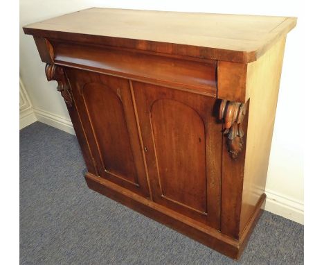 A mid-19th century mahogany side cabinet, full-width concave drawer above two panelled doors enclosing shelf, raised on plint