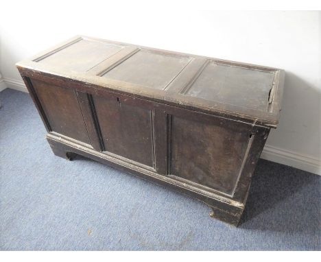 An 18th century three-panelled oak chest on bracket feet