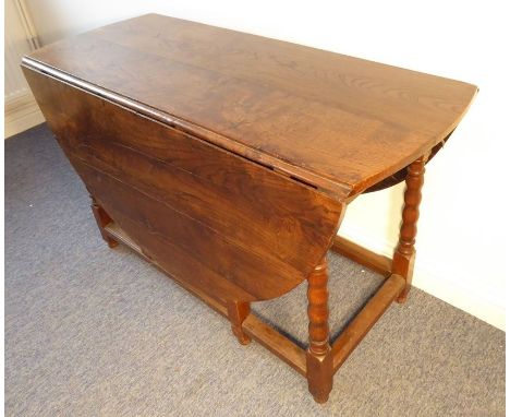 A large oval oak drop-leaf gate-leg table; in late 17th century style (later)&nbsp;with bobbin-turned supports united by stre