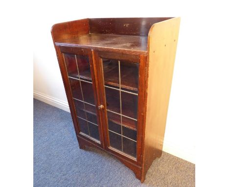 An early 20th century mahogany bookcase/display cabinet of slim proportions, galleried top above two leaded-glass doors inclu