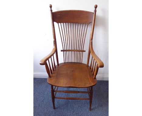 An early 20th century American style Arts and Crafts stick-back armchair having large shaped seat and standard turned legs un