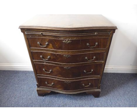 A late 18th century style (reproduction) serpentine-fronted mahogany chest; the cross-banded top above a brushing slide and f