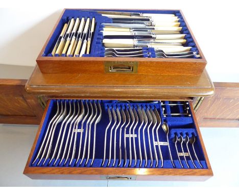 An early 20th century oak-cased table-top three-drawer silver-plated flatware/cutlery service for 12 (some pieces missing som