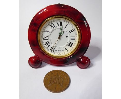 A Verdura miniature travel clock; red-and-brown faux-marble case surrounding a gold insert and white-enamel dial with Roman n