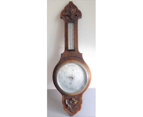 An early 20th century oak-cased wall-hanging aneroid barometer