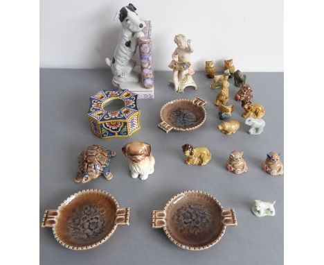 An assortment of small ornamental porcelain wares to include a late 19th century porcelain bookend modelled as a terrier lean