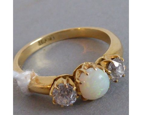 An 18-carat yellow-gold dress ring centrally set with a cabochon opal flanked either side by a solitaire diamond, ring size Q