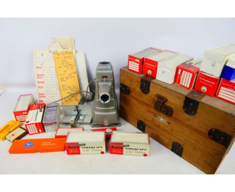 A vintage Aldis slide projector and accessories contained in metal mounted wooden box with a quantity of slide magazines, som