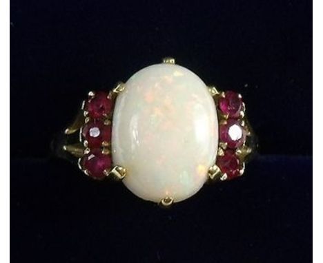 An 18k gold ruby and opal ring - size J 1/2