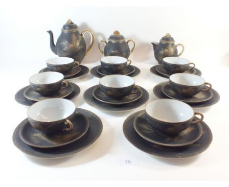 A Japanese satsuma porcelain tea set in black and gold comprising: eight cups and saucers, twelve tea plates, teapot, milk an