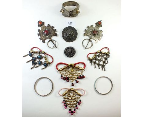 A group of white metal tribal and ethnic jewellery including large brooch pins with enamel decoration, bracelet, bangle etc