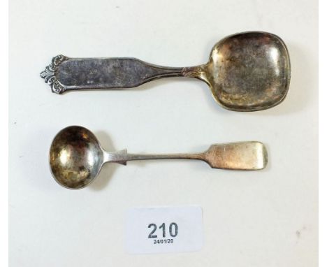 A silver salt spoon and a white metal continental caddy spoon